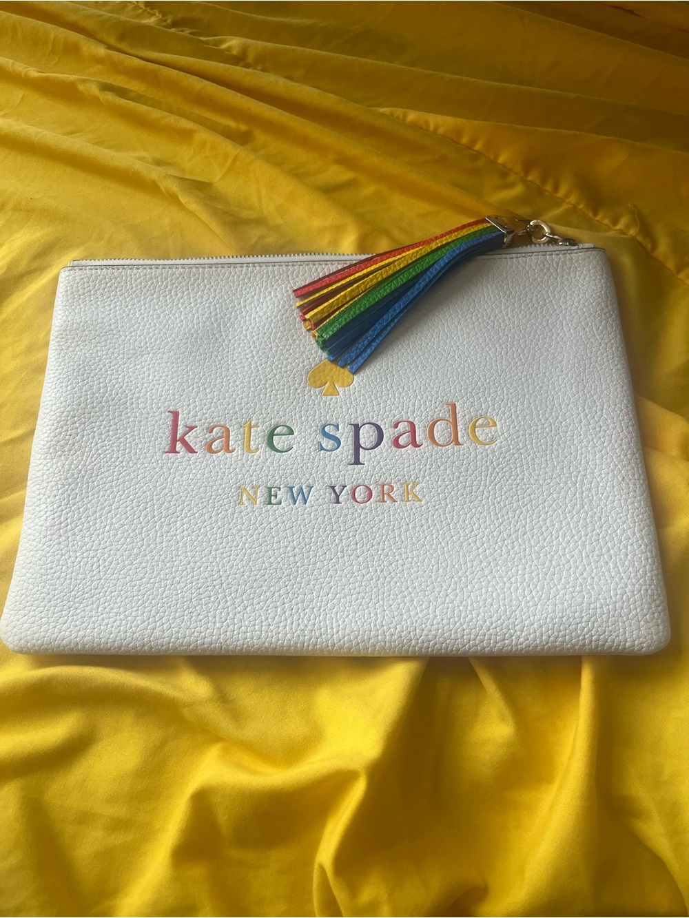 kate spade white leather pouch with rainbow logo and tassel